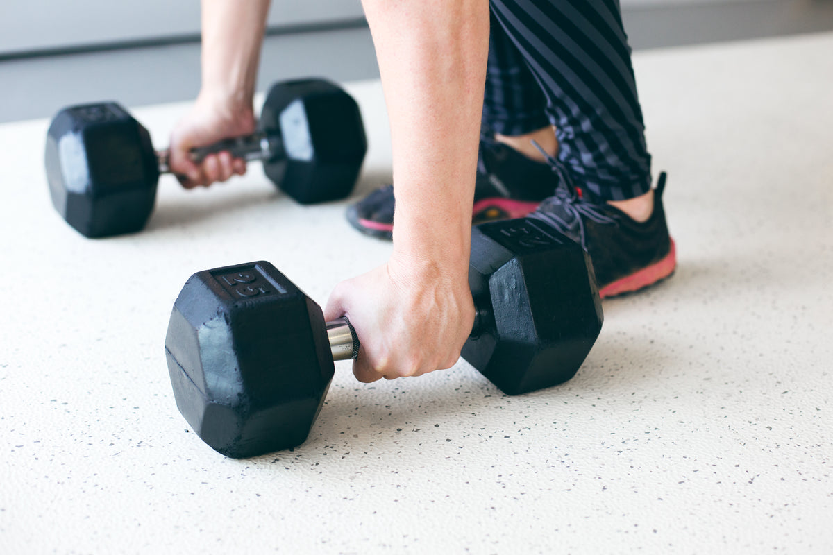 A woman lifting weights while another jogs outdoors, representing a balanced approach to exercise for weight loss.
