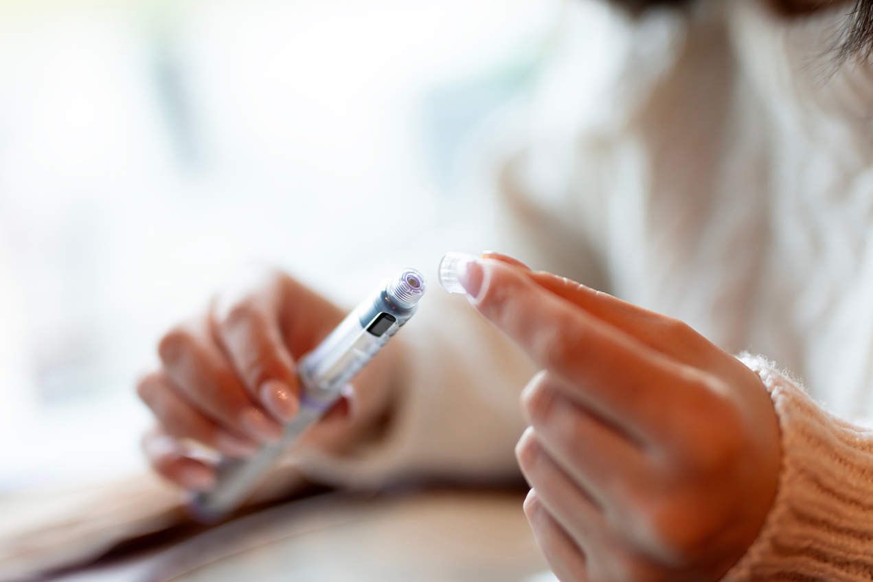 Person holding a semaglutide injection pen while considering starting Ozempic or Wegovy for weight management
